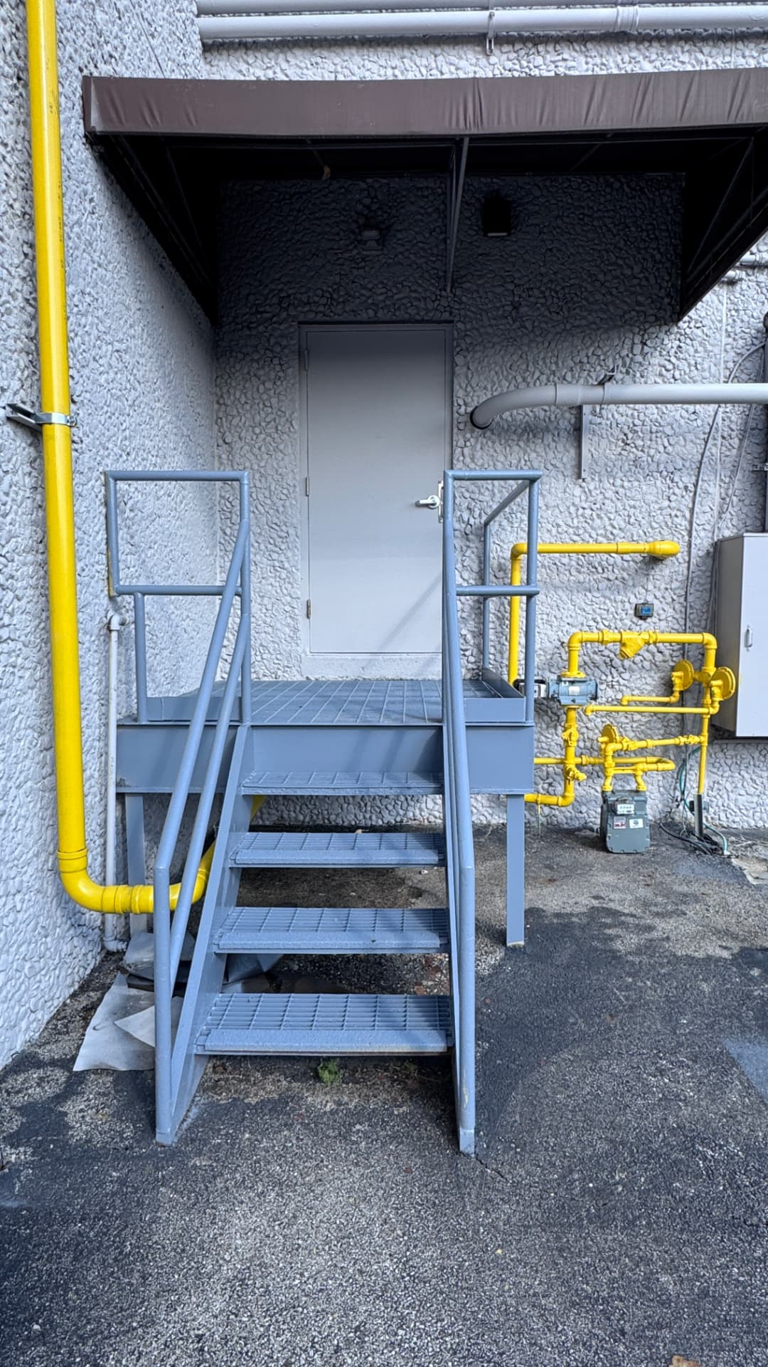 Repainted stair steel, guardrail, and yellow gas piping detail