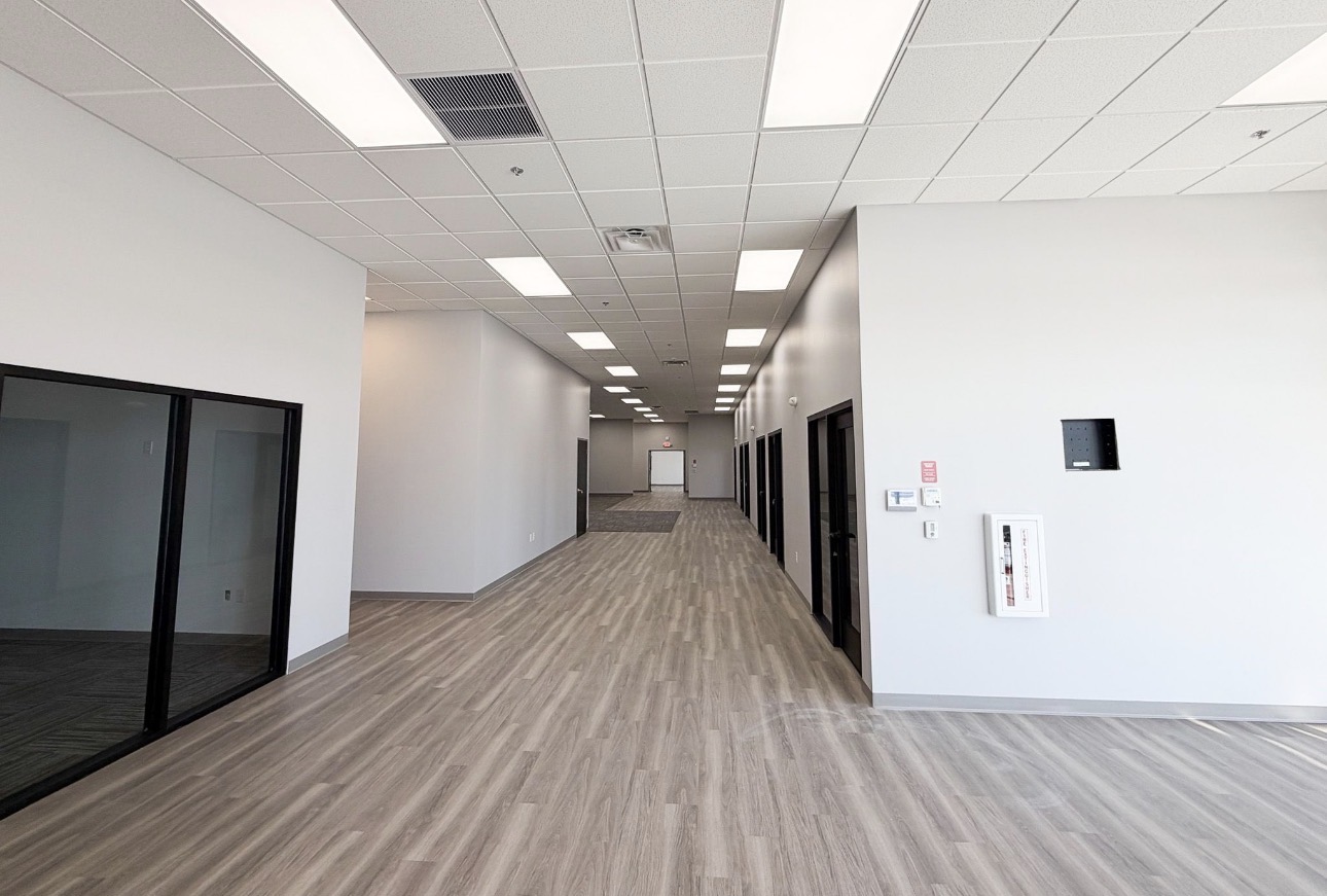 Office corridor with coated walls and dark hollow-metal frames