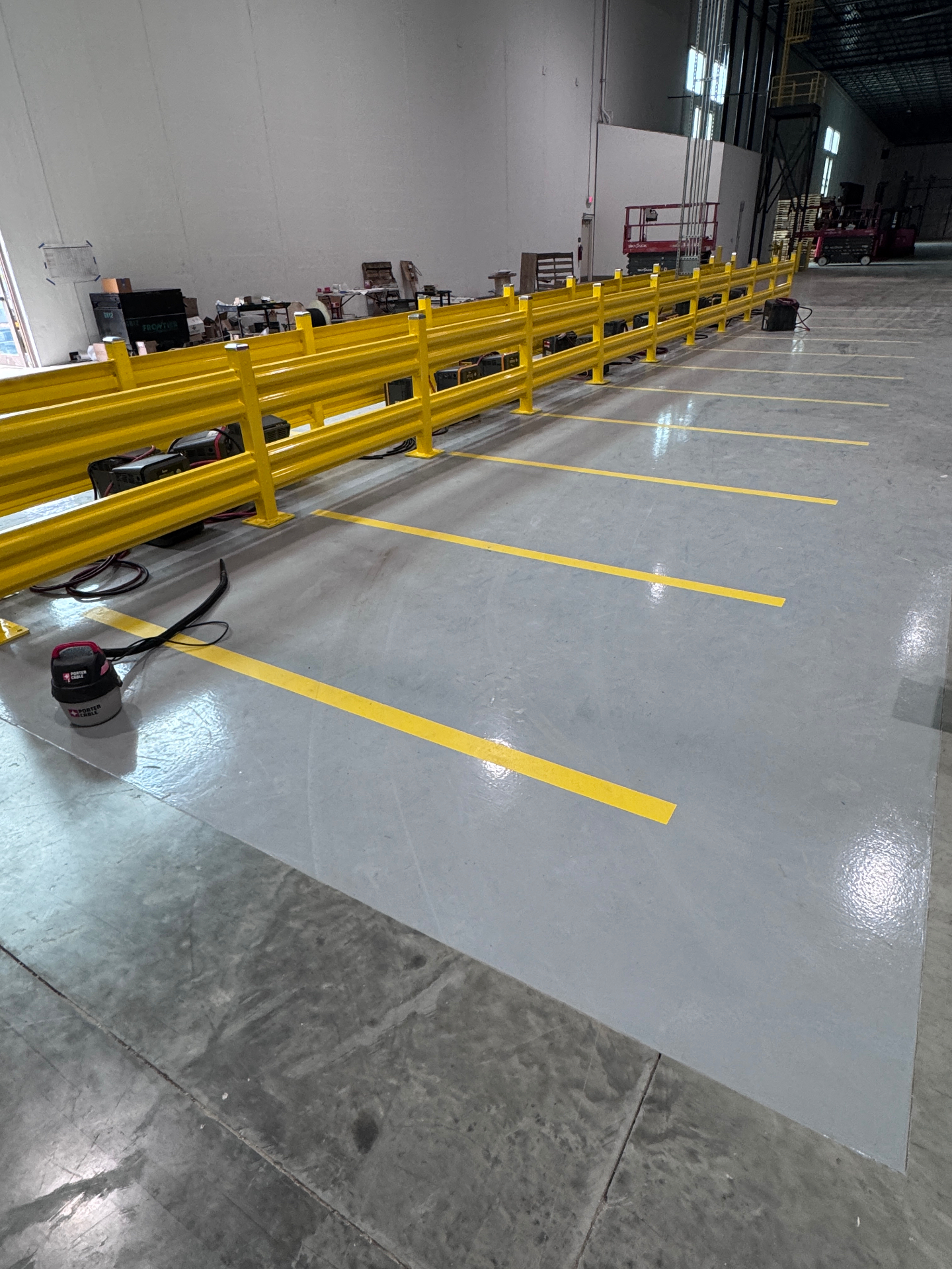 Striped charging bays along the guardrail with the coated footprint meeting bare slab