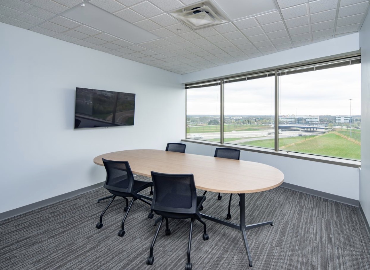 Perimeter meeting room with neutral field walls and daylight