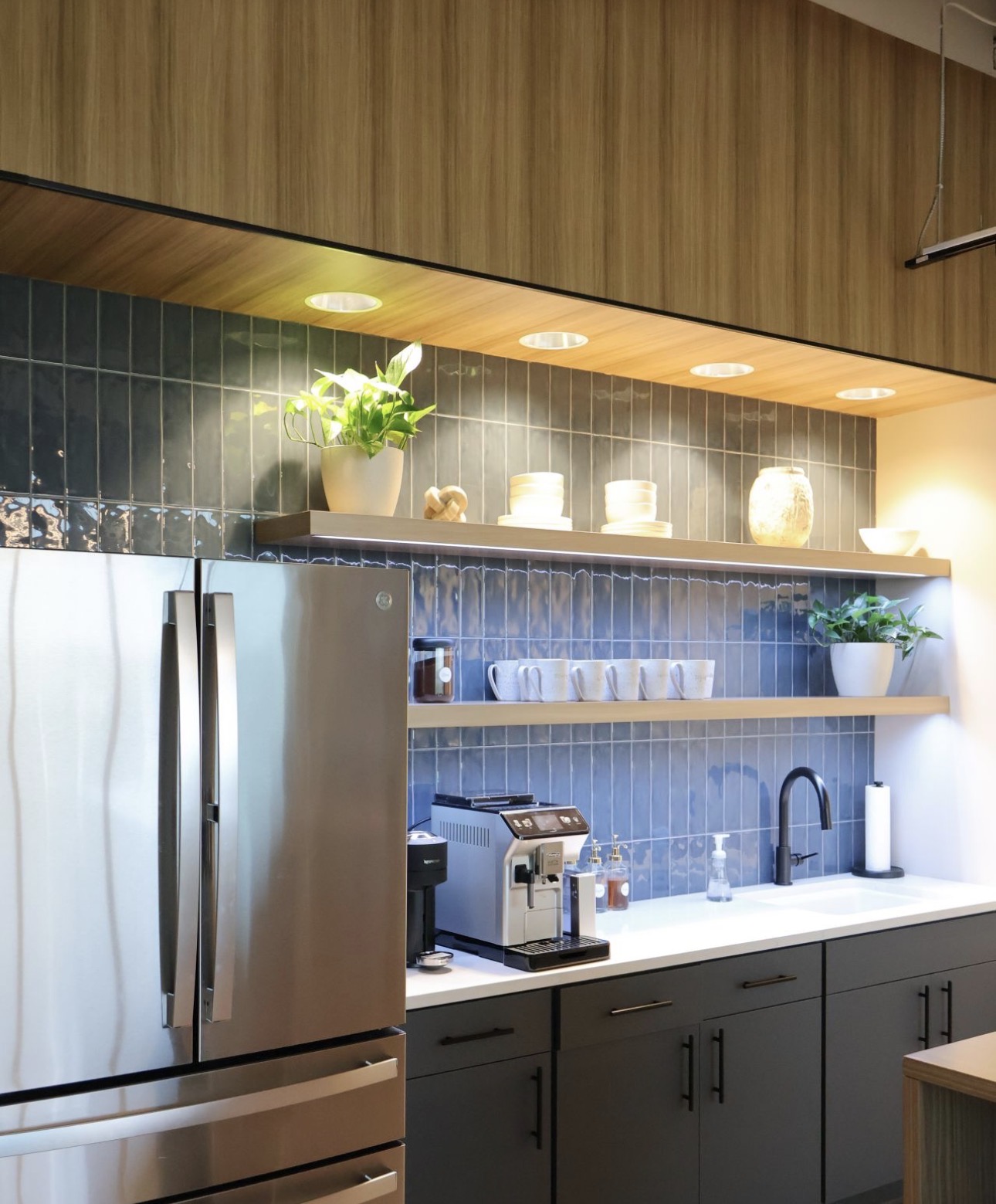 Pantry with tile backsplash, dark casework, and washable wall finish